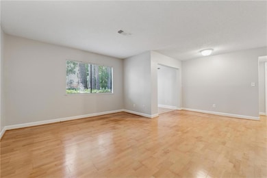 Spare room featuring light wood-style flooring and baseboards