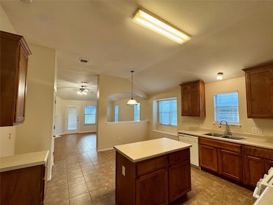 Kitchen with white dishwasher, light tile pattern