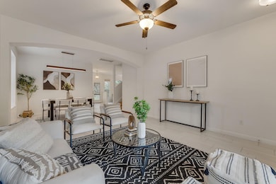 The living area leads into a dining space anchored by statement lighting and natural tones.