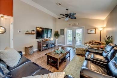 Living room featuring ceiling fan, high vaulted ce