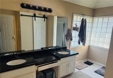 Bathroom with double vanity, curtained shower, til