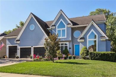 2- View of front featuring driveway, a front yard, stucco siding, metal roof, several windows and lots of beautiful landscaping