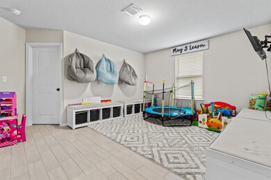 Playroom with a textured ceiling and wood finished floors