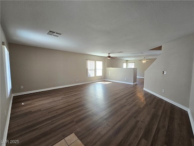 Unfurnished room featuring a textured ceiling and dark wood-style floors