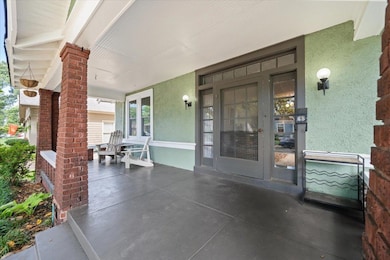 View of exterior entry with stucco siding and a porch