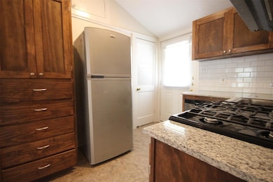 Kitchen featuring freestanding refrigerator, loft