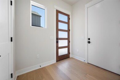 Foyer entrance featuring baseboards and light woo