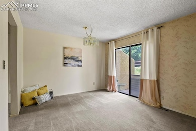 Spare room featuring carpet floors, a textured cei