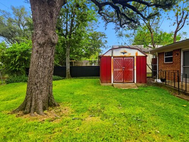 Fenced backyard featuring a storage shed