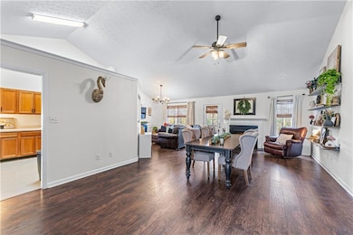 Dining space featuring lofted ceiling, a lit firep