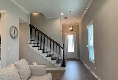 Foyer featuring dark wood-style floors, stairs, an