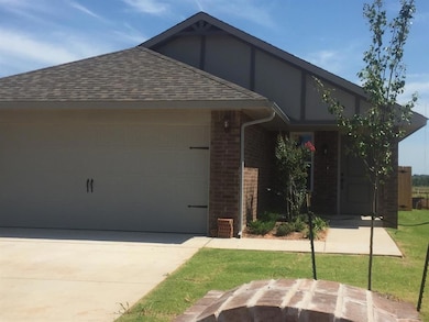 View of front of home with brick siding, roof with shingles, an attached garage, and driveway