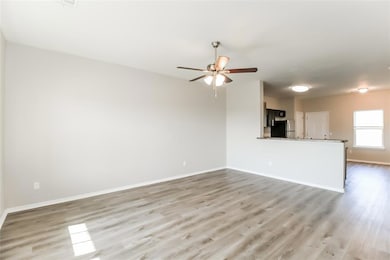 Unfurnished living room with ceiling fan and light
