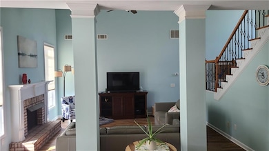 Living room featuring decorative columns, a firepl