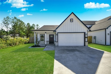 Charming Modern Farmhouse style home featuring white board-and-batten siding, black trim, and a two-car garage.