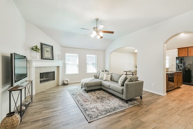 The lovely living room with high ceilings, plenty of natural light, and fireplace.