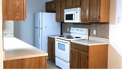 Kitchen featuring white appliances, light counter