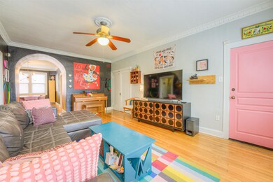 Living area with arched walkways, baseboards, wood
