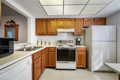 Kitchen with white appliances and sink