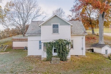 Front view of house featuring a yard, a chimney, and an outbuilding