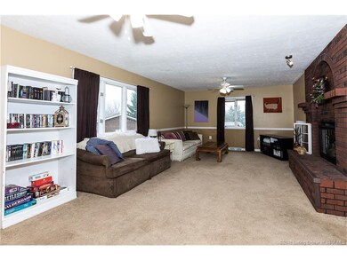 THE LIVING ROOM HAS NETURAL COLORS AND CARPET.