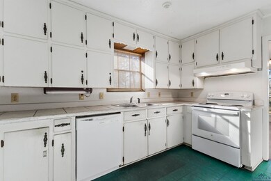 Kitchen featuring white cabinets, white appliances