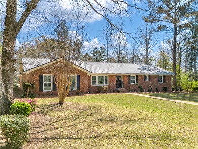 Single story home featuring brick siding, metal ro
