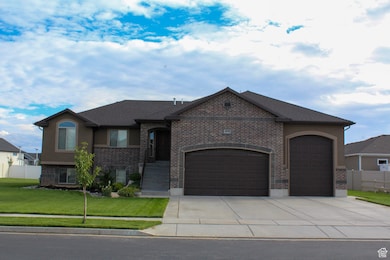 View of front of home with an attached garage, concrete driveway, brick siding, and stucco siding