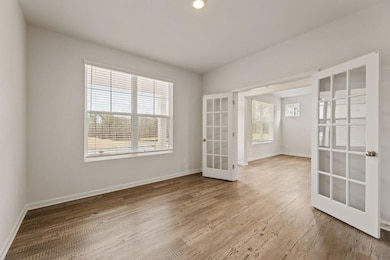 Spare room featuring french doors, baseboards, and