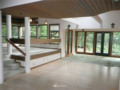 From the formal dinning area you see the fireside area, the living room, sun room and access to the outside. The covered hot tub area can also be seen.