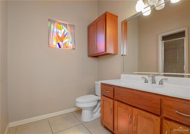 Bathroom with toilet, vanity, and tile patterned floors