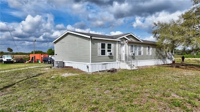 View of side of property with central AC and a yar