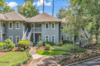 View of front of property featuring stairs, roof with shingles, and a front yard