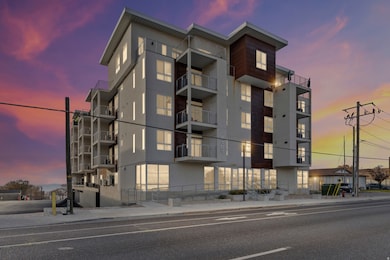 Property at dusk featuring a view of apartment building / complex