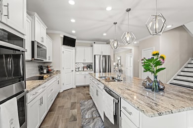 Kitchen featuring white cabinets, backsplash, stai