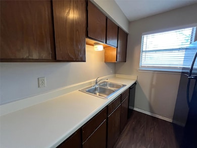 This view of the kitchen shows the large counterspace, the stainless steel double sink, and tons of cabinets.