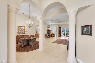 Enter through the grand foyer with soaring ceilings, columns, and open views through the home.