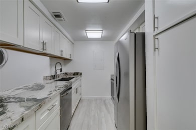Kitchen with stainless steel appliances, a sink, l