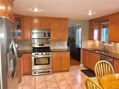 Honey oak cabinets, quartz countertops and stainle