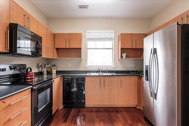 Kitchen with black appliances, open shelves, and dark wood finished floors