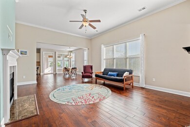 Living room with ceiling fan with notable chandeli