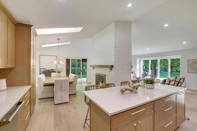 AFTER kitchen to dining....designer light fixtures, handles and pulls. Beautiful wood burning fireplace with oak mantel!