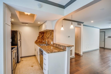 Kitchen featuring sink, white cabinetry, decorativ
