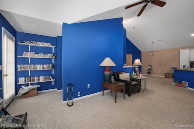 Sitting room with light colored carpet, lofted ceiling, and ceiling fan