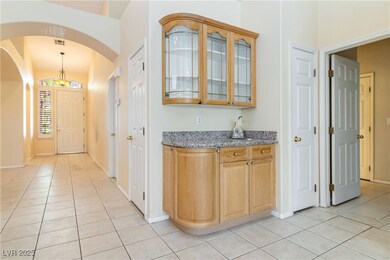 Entryway with light tile patterned floors and arch