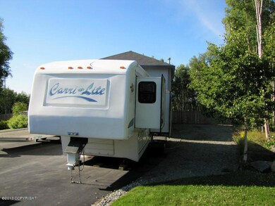 Gravel RV parking pad next to driveway.