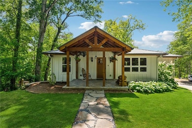 Modern inspired farmhouse with board and batten siding, a front yard, and metal roof