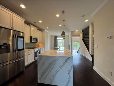 Kitchen featuring appliances with stainless steel finishes, backsplash, recessed lighting, an island with sink, and dark wood-style flooring