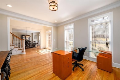 Office space featuring light wood-style floors, ornamental molding, recessed lighting, and baseboards - can be converted back into a formal living room