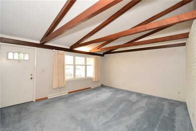 Living Room is vaulted with wood beams and a brick
